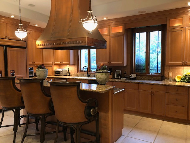 Example of a classic kitchen design with medium tone wood cabinets and granite countertops