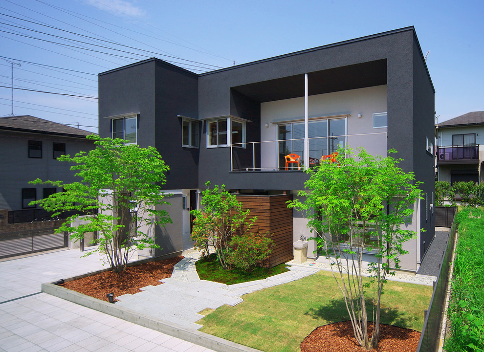 Inspiration for a contemporary two-storey black exterior in Other with mixed siding and a flat roof.