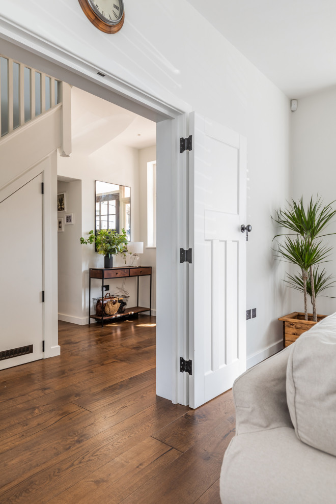 Inspiration pour une grande entrée traditionnelle avec un couloir, un mur blanc, parquet foncé, une porte double, une porte en bois foncé et un sol marron.