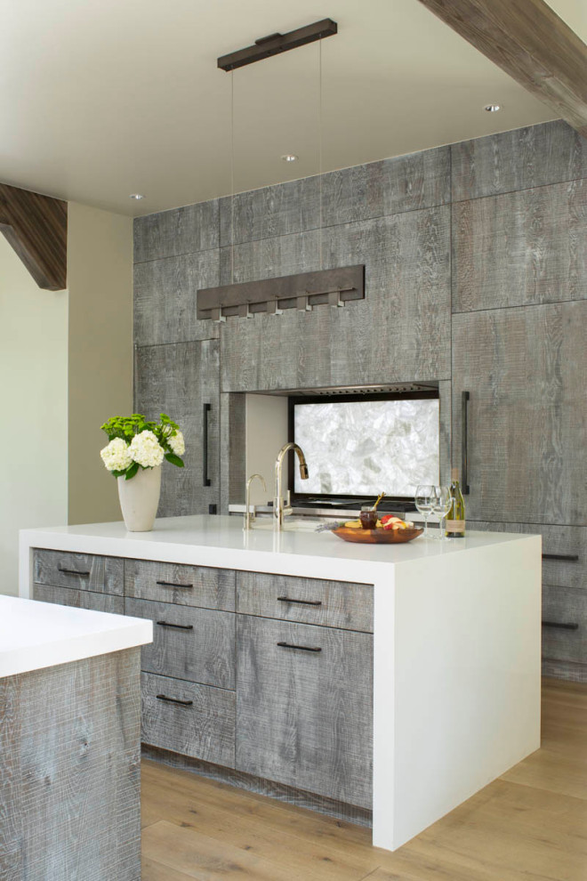 Inspiration for a rustic light wood floor, brown floor and exposed beam kitchen remodel with flat-panel cabinets, distressed cabinets, white backsplash, an island and white countertops