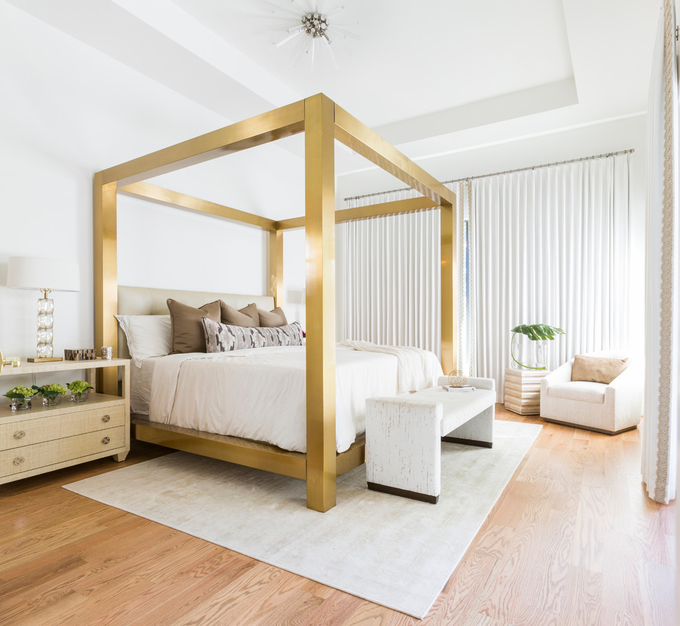 This is an example of a contemporary master bedroom in Houston with white walls, light hardwood floors and beige floor.