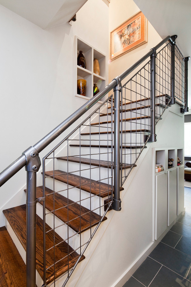 Mid-sized industrial wood u-shaped staircase in Austin with painted wood risers.