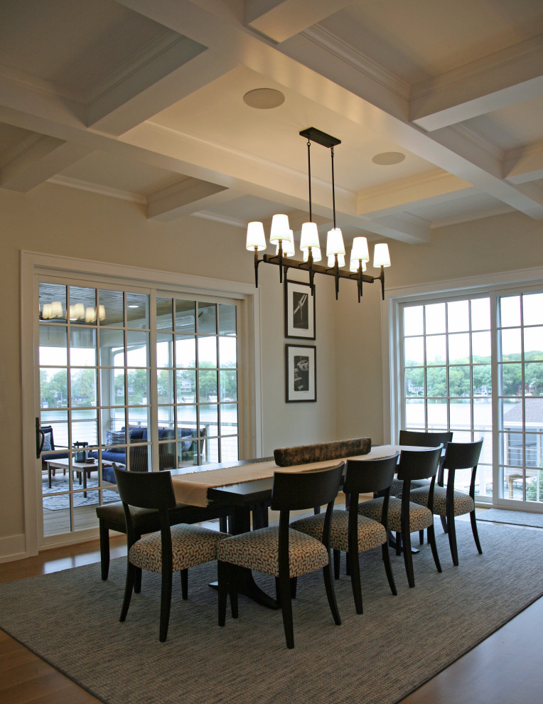 Ispirazione per una sala da pranzo aperta verso la cucina stile marinaro di medie dimensioni con pareti beige, parquet chiaro, pavimento marrone e soffitto a cassettoni