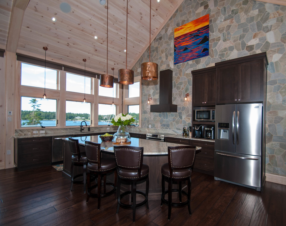 Example of a large transitional l-shaped dark wood floor and brown floor eat-in kitchen design with an undermount sink, shaker cabinets, dark wood cabinets, granite countertops, beige backsplash, stone tile backsplash, stainless steel appliances and an island