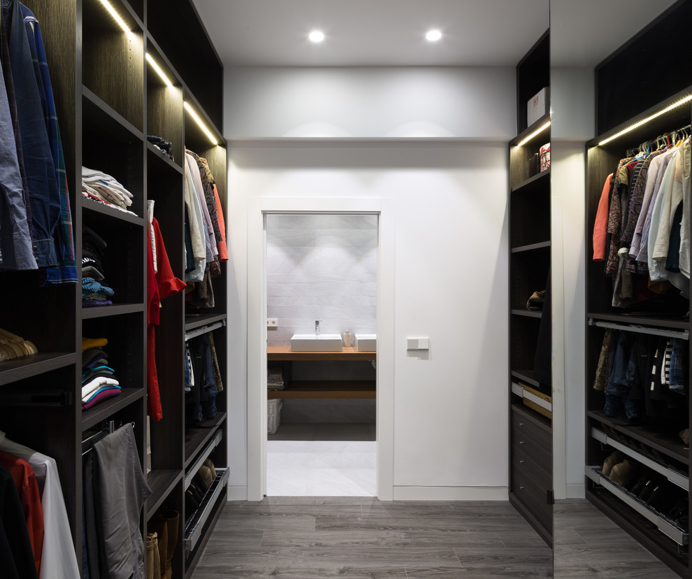 Mid-sized contemporary gender-neutral walk-in wardrobe in Other with open cabinets and black cabinets.