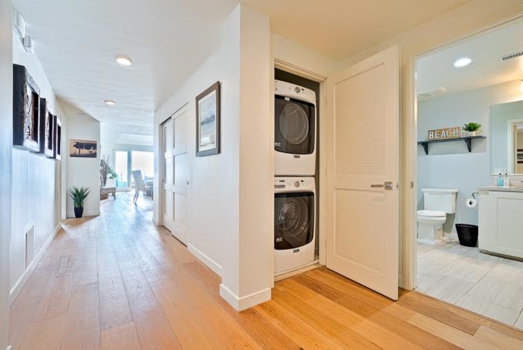 Inspiration for a beach style laundry room in San Diego with a stacked washer and dryer.