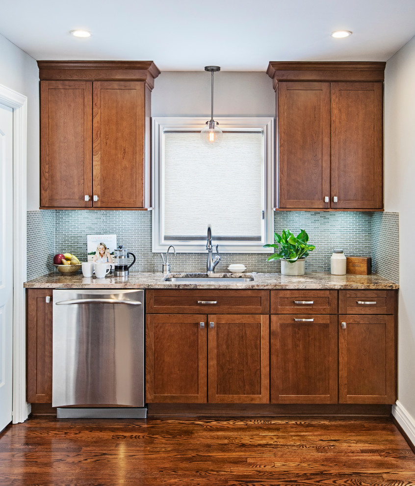 This is an example of a small transitional l-shaped kitchen in Detroit with an undermount sink, shaker cabinets, medium wood cabinets, granite benchtops, grey splashback, stainless steel appliances and medium hardwood floors.