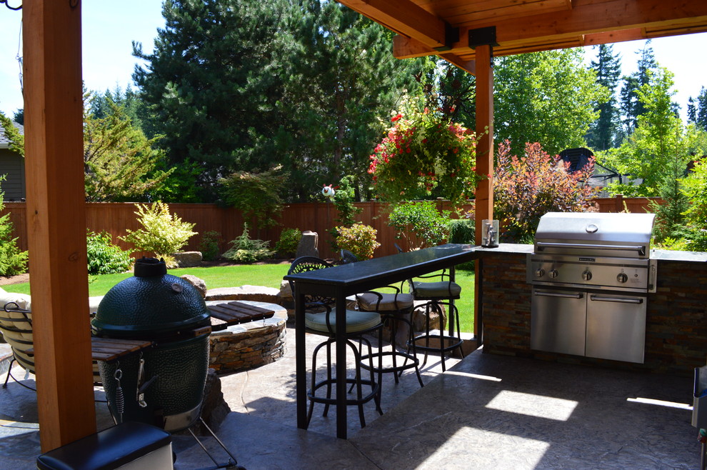Design ideas for a mid-sized eclectic patio in Seattle with stamped concrete and a roof extension.