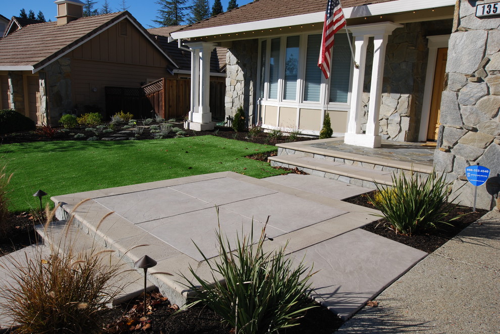 Photo of a large contemporary front yard patio in San Francisco with stamped concrete and an awning.