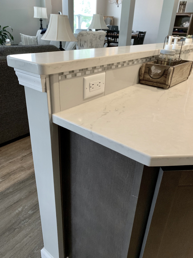 Large transitional u-shaped vinyl floor and gray floor open concept kitchen photo with an undermount sink, shaker cabinets, gray cabinets, quartz countertops, gray backsplash, ceramic backsplash, stainless steel appliances, a peninsula and white countertops