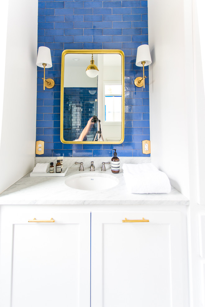 Photo of a mid-sized modern 3/4 bathroom in Minneapolis with recessed-panel cabinets, white cabinets, an open shower, blue tile, ceramic tile, white walls, ceramic floors, a drop-in sink, marble benchtops, white floor and white benchtops.