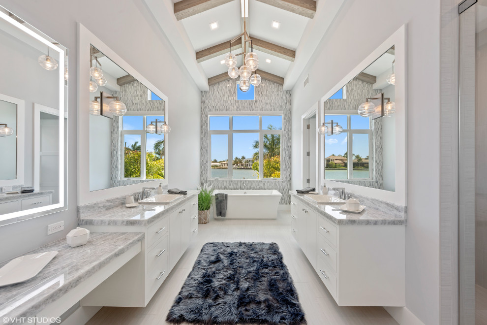 This is an example of a large beach style master bathroom in Tampa with open cabinets, white cabinets, a freestanding tub, a double shower, a two-piece toilet, multi-coloured tile, glass tile, green walls, slate floors, a drop-in sink, onyx benchtops, white floor, a hinged shower door and blue benchtops.