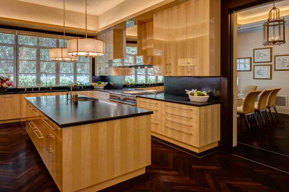 This is an example of a contemporary l-shaped kitchen in Houston with an undermount sink, flat-panel cabinets, mirror splashback, dark hardwood floors, with island, brown floor, light wood cabinets and stainless steel appliances.