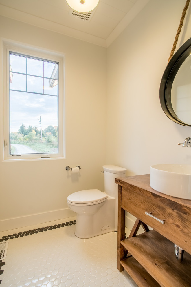 Photo of a small transitional powder room in Toronto with furniture-like cabinets, light wood cabinets, a two-piece toilet, white walls, ceramic floors, a vessel sink, wood benchtops and brown benchtops.