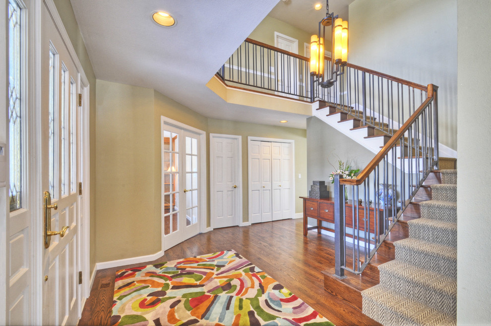 Large transitional medium tone wood floor foyer photo in Denver with beige walls and a white front door