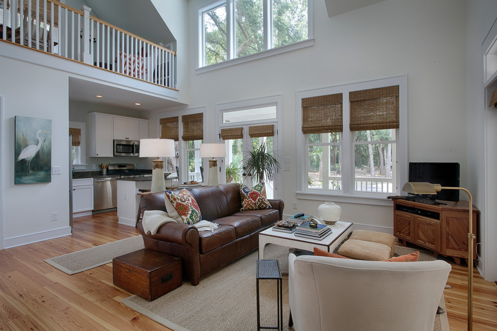 Tropical open concept living room in Charleston with medium hardwood floors and a corner tv.