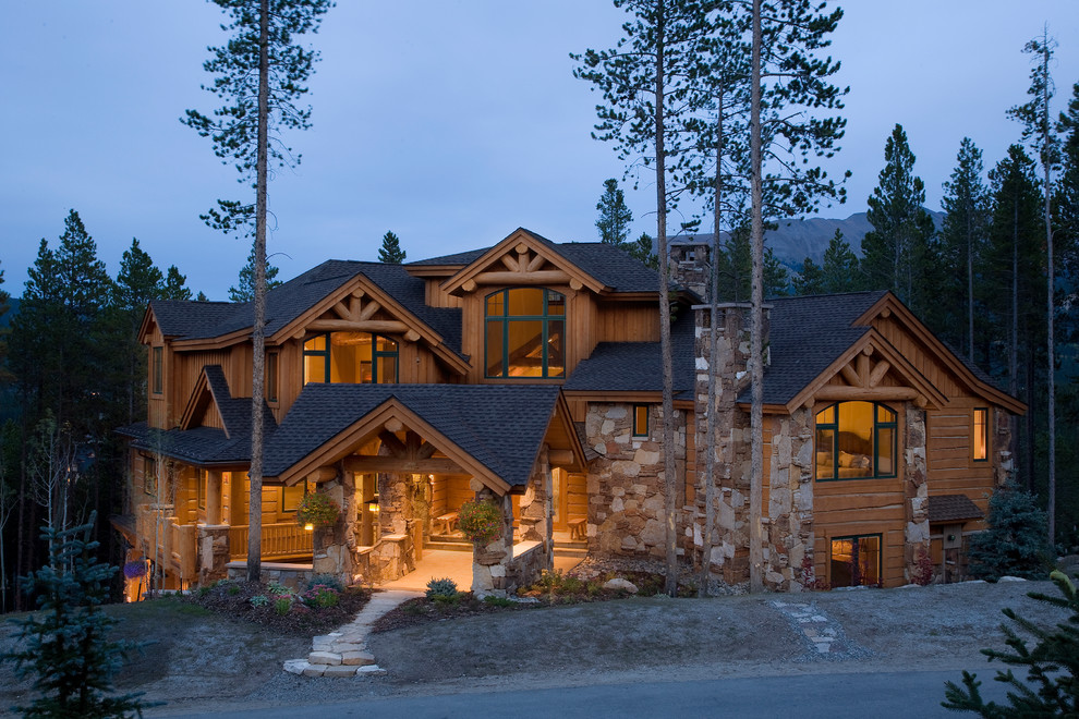 Photo of an expansive traditional three-storey brown exterior in Denver with stone veneer.