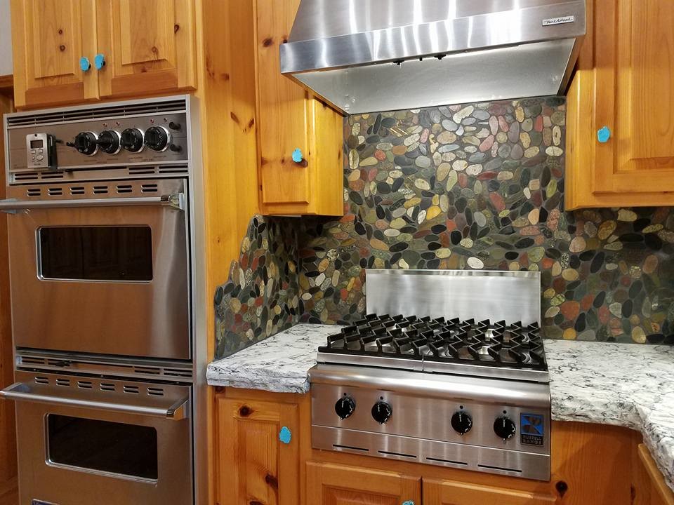 Inspiration for a large rustic u-shaped eat-in kitchen remodel in Sacramento with an undermount sink, raised-panel cabinets, medium tone wood cabinets, quartz countertops, multicolored backsplash, stainless steel appliances and a peninsula