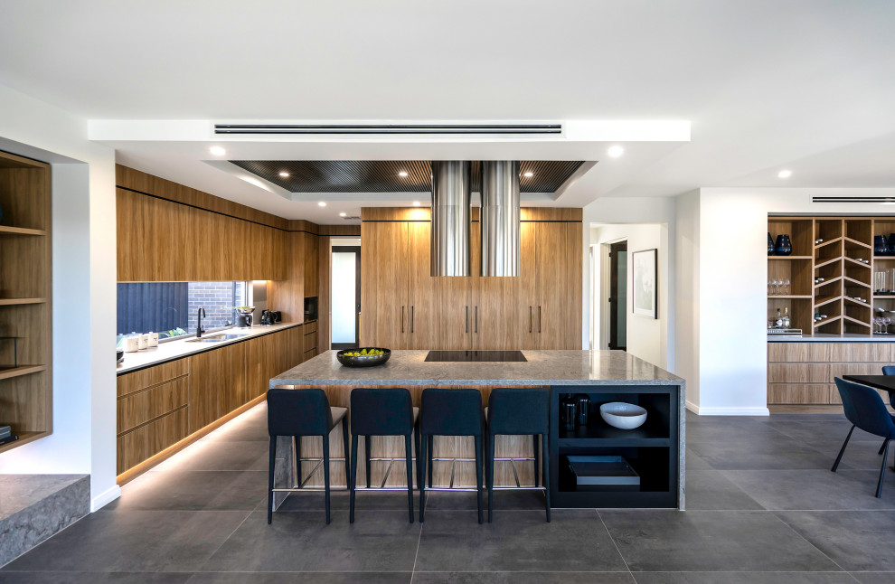 Design ideas for a contemporary l-shaped open plan kitchen in Sydney with an undermount sink, flat-panel cabinets, medium wood cabinets, window splashback, with island, grey floor and grey benchtop.
