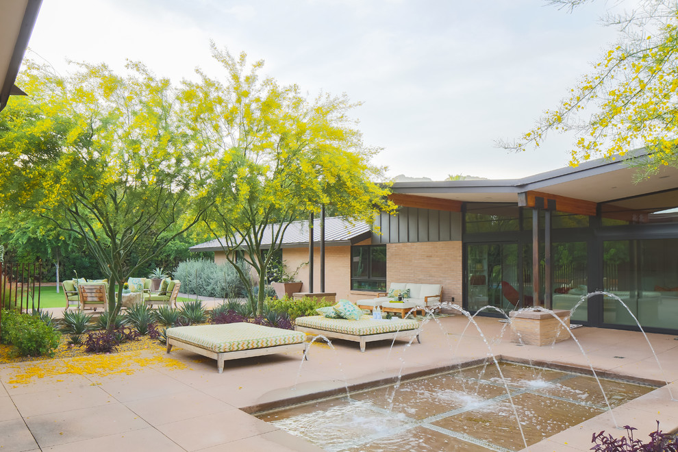 Photo of a midcentury courtyard full sun xeriscape in Phoenix with a water feature and concrete pavers.