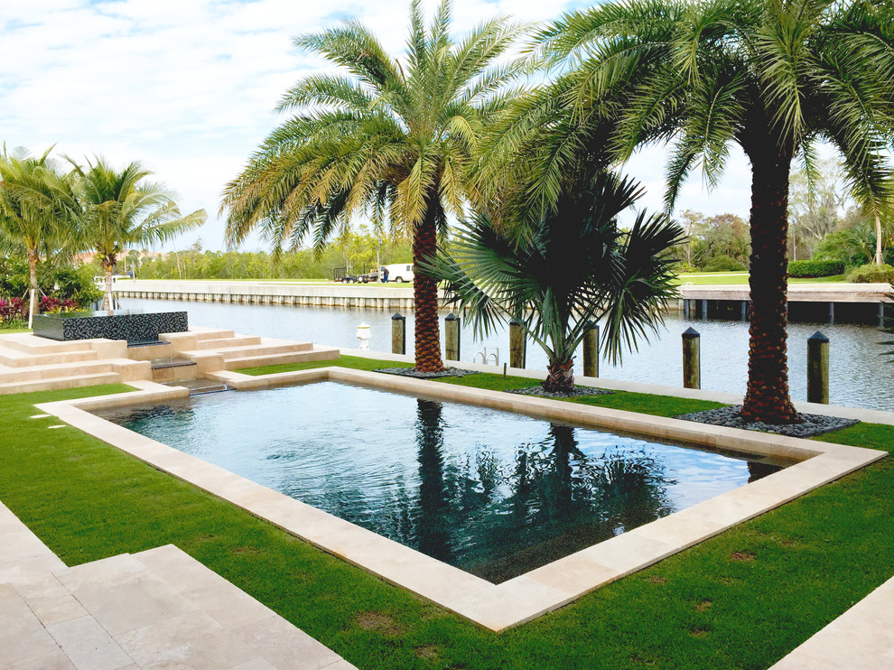 This is an example of a mid-sized tropical backyard rectangular pool in Miami.