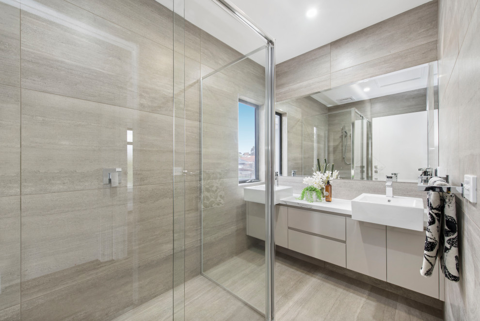 Design ideas for a large contemporary master bathroom in Melbourne with recessed-panel cabinets, beige cabinets, a double shower, a two-piece toilet, beige tile, porcelain tile, beige walls, porcelain floors, a wall-mount sink, quartzite benchtops, beige floor, a hinged shower door, white benchtops, a double vanity and a built-in vanity.