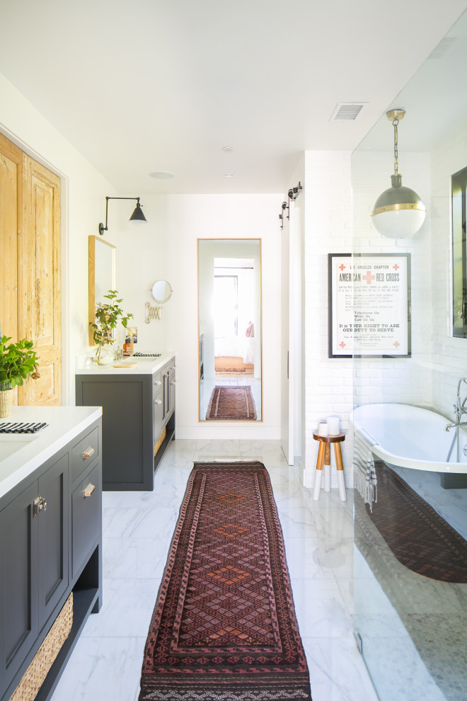 Example of a beach style white tile white floor and single-sink freestanding bathtub design in Orange County with shaker cabinets, gray cabinets, white walls, an undermount sink, white countertops and a freestanding vanity