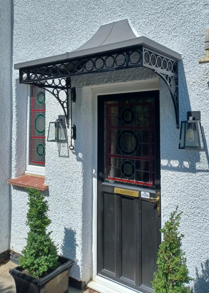 ケントにある低価格の小さなトラディショナルスタイルのおしゃれな玄関ドア (青い壁、黒いドア) の写真