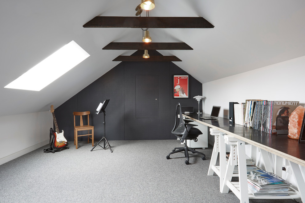 This is an example of a mid-sized home studio in Melbourne with black walls, carpet, no fireplace and a freestanding desk.