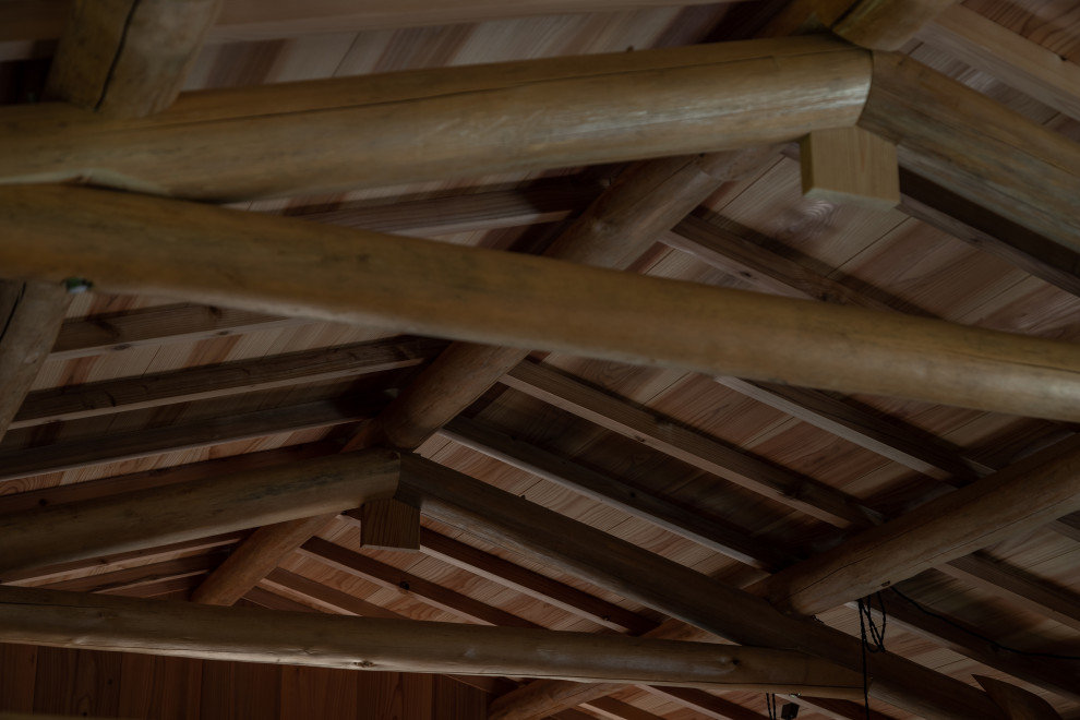 他の地域にある広いラスティックスタイルのおしゃれなファミリールーム (表し梁、ベージュの天井) の写真