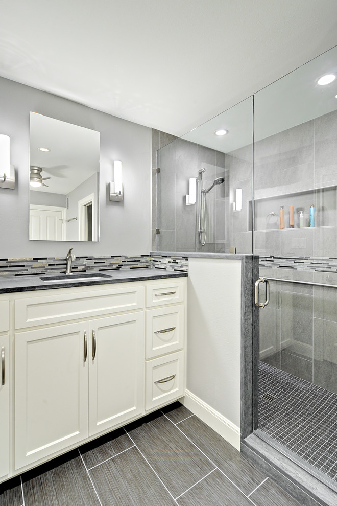 Design ideas for a small transitional bathroom in Austin with an undermount sink, shaker cabinets, white cabinets, limestone benchtops, a one-piece toilet, gray tile, porcelain tile, grey walls, porcelain floors and a corner shower.