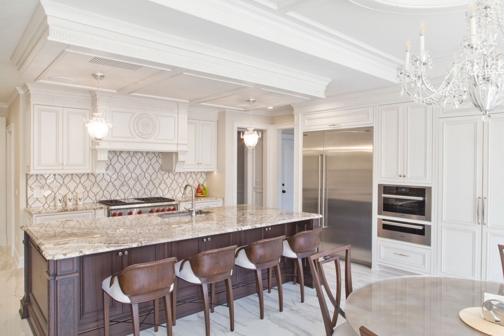 Large contemporary u-shaped kitchen/diner in New York with a built-in sink, shaker cabinets, white cabinets, engineered stone countertops, grey splashback, stainless steel appliances, an island, grey floors, beige worktops and a vaulted ceiling.
