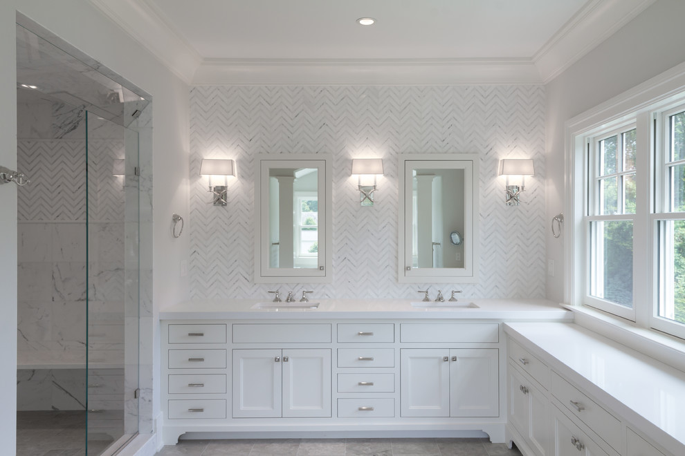 Inspiration for a large transitional master bathroom in New York with recessed-panel cabinets, white cabinets, engineered quartz benchtops, white tile, an undermount sink, white walls and marble floors.