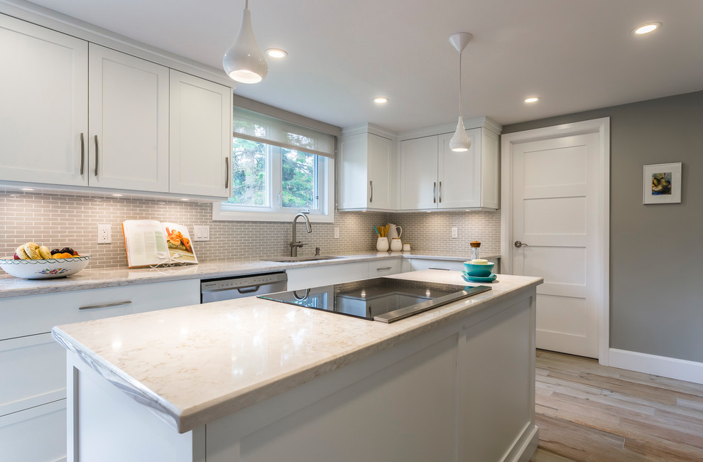 Inspiration for a mid-sized transitional l-shaped porcelain tile and beige floor eat-in kitchen remodel with an undermount sink, shaker cabinets, white cabinets, quartz countertops, gray backsplash, mosaic tile backsplash, stainless steel appliances and an island