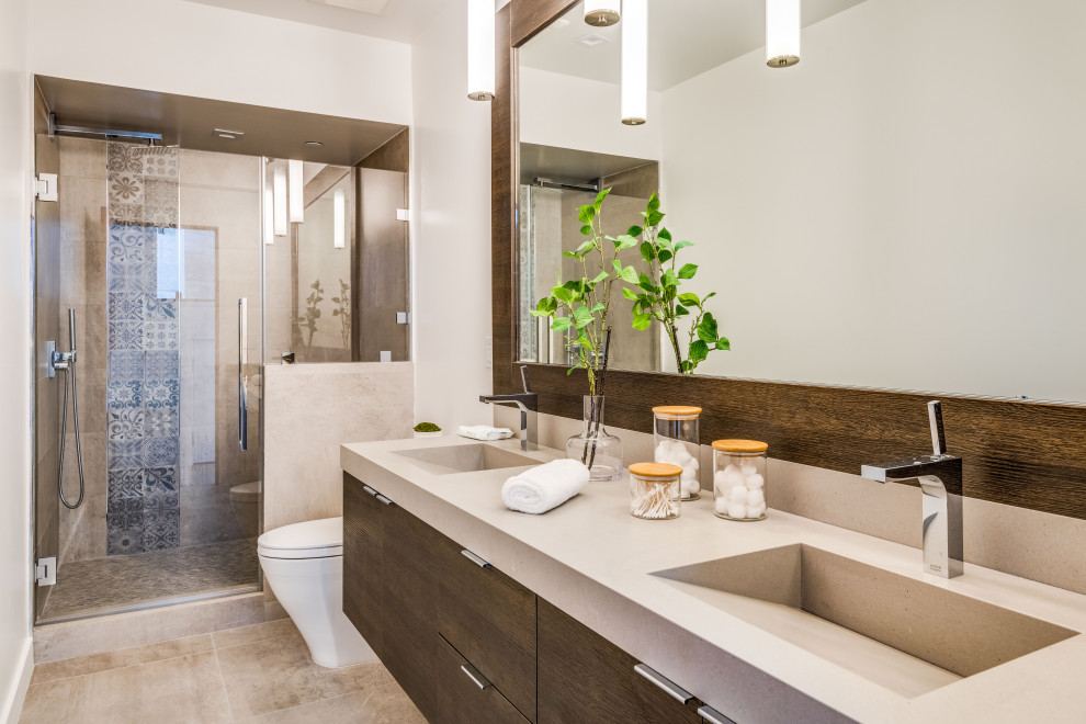 Large contemporary master bathroom in Los Angeles with flat-panel cabinets, dark wood cabinets, a double shower, a two-piece toilet, white tile, marble, beige walls, cement tiles, an integrated sink, marble benchtops, brown floor, a hinged shower door, white benchtops and a double vanity.