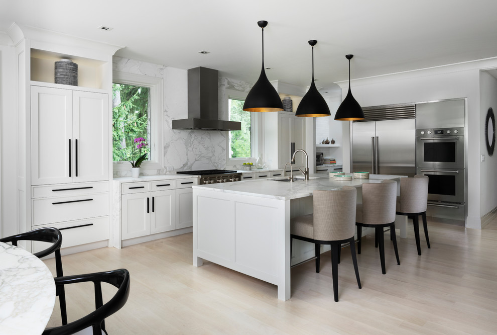 Design ideas for a transitional eat-in kitchen in Detroit with an undermount sink, shaker cabinets, white cabinets, marble benchtops, white splashback, marble splashback, stainless steel appliances, light hardwood floors, with island and white benchtop.