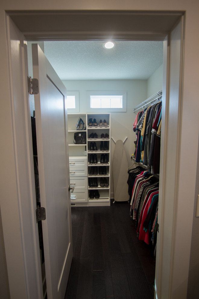 Large transitional gender-neutral walk-in wardrobe in Other with recessed-panel cabinets, brown cabinets and dark hardwood floors.