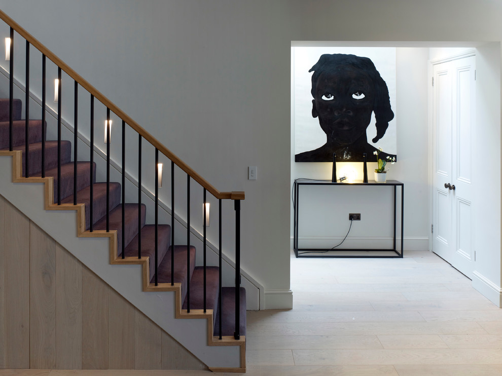 Photo of a contemporary wood staircase in London with wood risers.