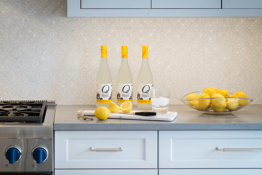Eat-in kitchen - large transitional single-wall laminate floor and beige floor eat-in kitchen idea in DC Metro with a farmhouse sink, flat-panel cabinets, blue cabinets, quartz countertops, white backsplash, mosaic tile backsplash, stainless steel appliances, an island and gray countertops