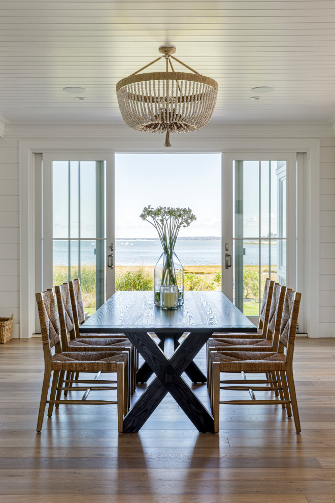 Exemple d'une salle à manger ouverte sur le salon bord de mer de taille moyenne avec un mur blanc, un sol en bois brun, aucune cheminée, un plafond en lambris de bois, du lambris de bois et un sol marron.