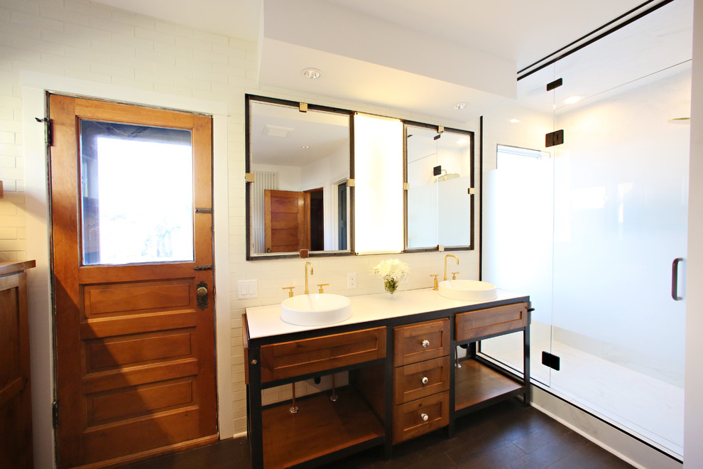 This is an example of a large industrial master bathroom in Minneapolis with a drop-in sink, recessed-panel cabinets, medium wood cabinets, concrete benchtops, a freestanding tub, an alcove shower, a one-piece toilet, white tile, porcelain tile, white walls, cork floors, brown floor and a hinged shower door.