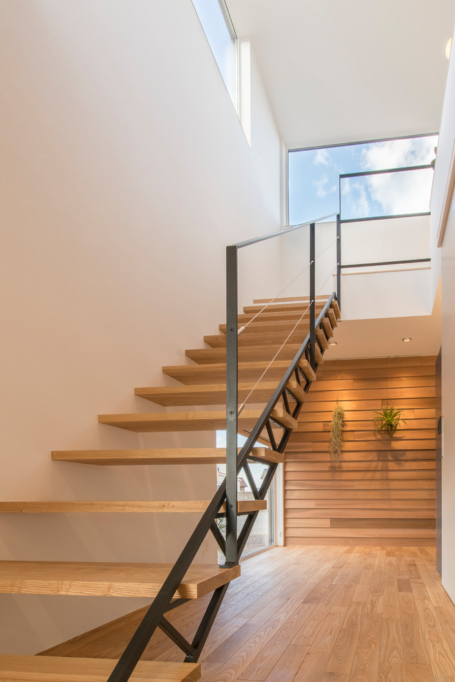 This is an example of a mid-sized modern wood straight staircase in Other with open risers and metal railing.