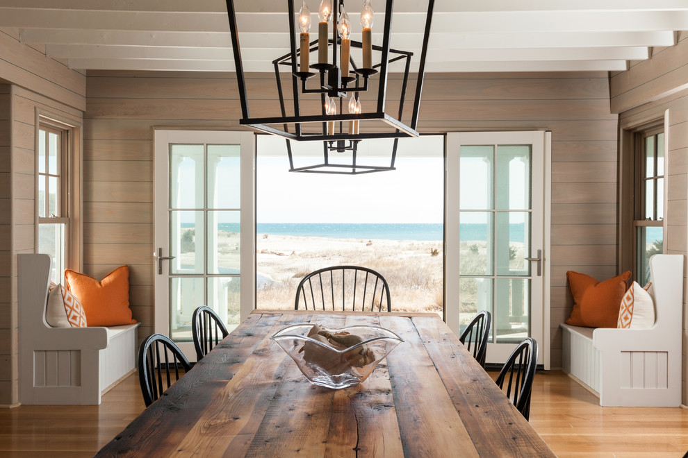 Beach style dining room in Boston with brown walls and light hardwood floors.