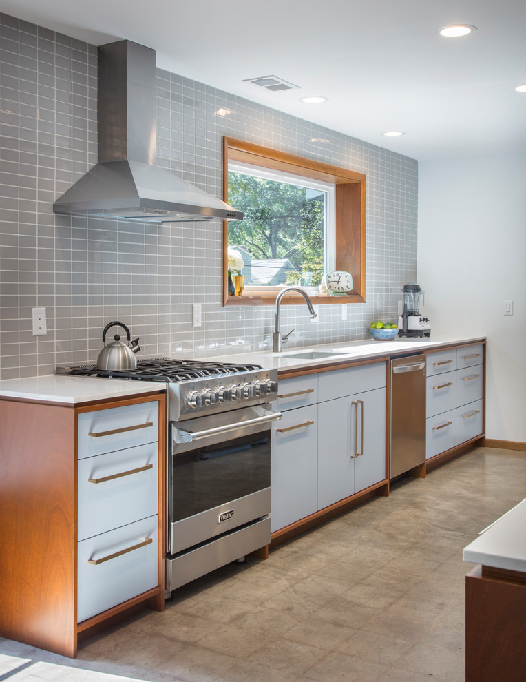 Mid-sized midcentury galley eat-in kitchen in Kansas City with an undermount sink, flat-panel cabinets, blue cabinets, quartz benchtops, grey splashback, porcelain splashback, stainless steel appliances, concrete floors, with island and grey floor.