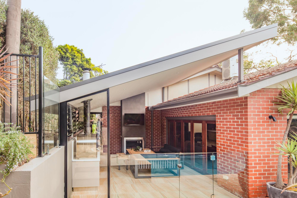 Inspiration pour une façade de maison grise minimaliste en panneau de béton fibré de taille moyenne et de plain-pied avec un toit en métal et un toit noir.