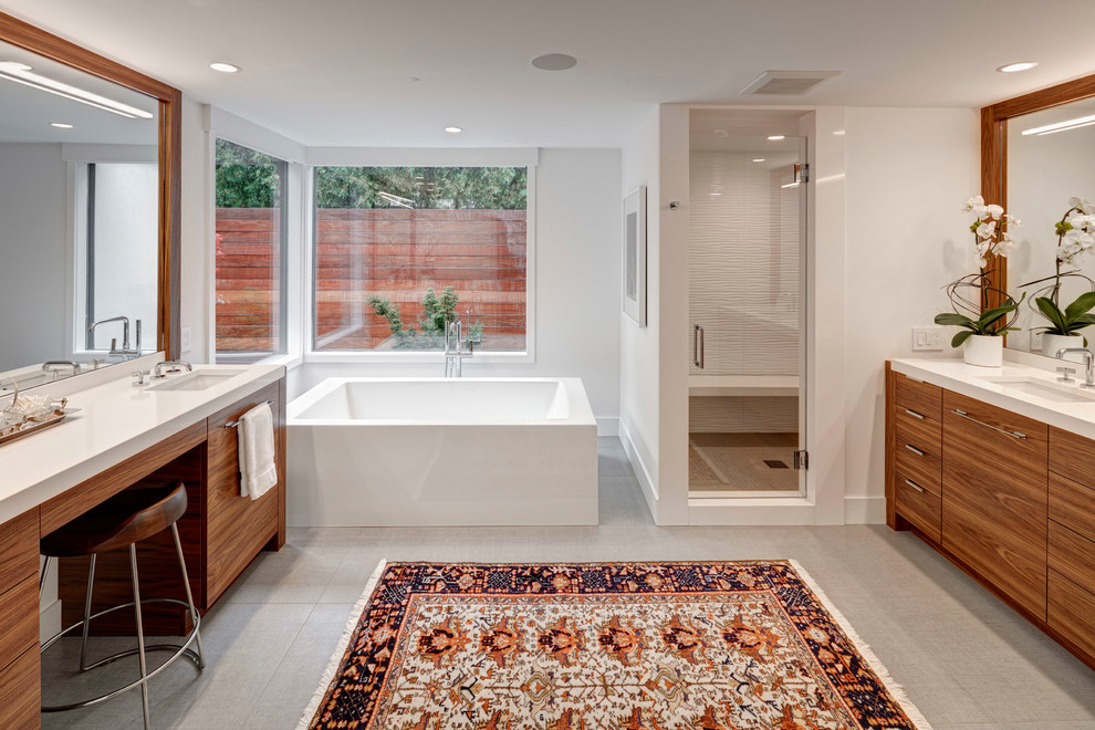 Large midcentury master bathroom in Detroit with flat-panel cabinets, medium wood cabinets, a freestanding tub, an alcove shower, white tile, white walls, an undermount sink, grey floor and a hinged shower door.