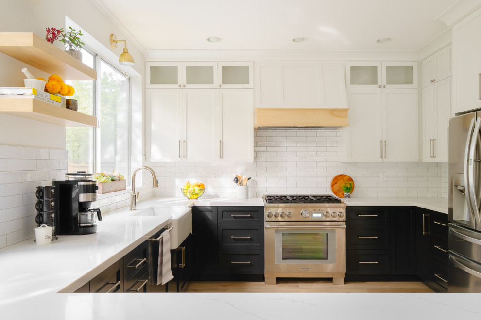 Exempel på ett mellanstort lantligt vit vitt kök, med en rustik diskho, skåp i shakerstil, svarta skåp, bänkskiva i kvarts, vitt stänkskydd, stänkskydd i tunnelbanekakel, rostfria vitvaror, vinylgolv, en halv köksö och beiget golv