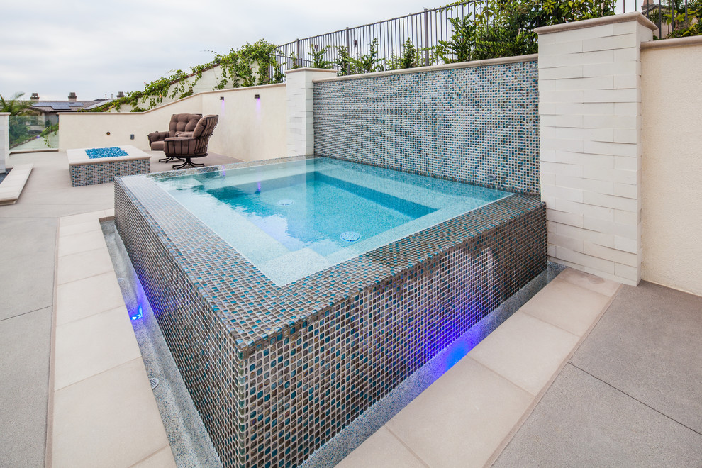 Photo of a mid-sized modern backyard rectangular pool in San Diego with a water feature and concrete slab.