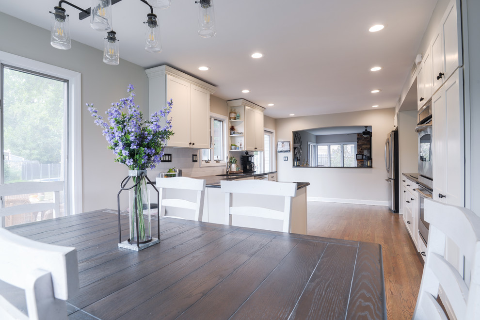 Kitchen - mid-sized transitional galley medium tone wood floor and brown floor kitchen idea in Philadelphia with an undermount sink, beaded inset cabinets, white cabinets, white backsplash, subway tile backsplash, stainless steel appliances and no island
