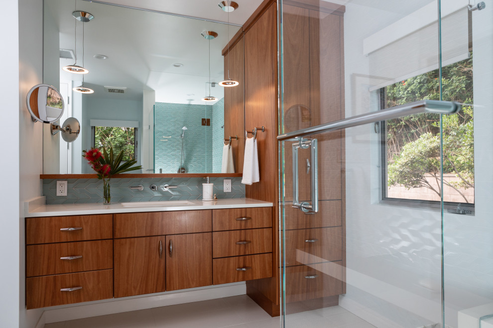 Design ideas for a medium sized retro shower room bathroom in Los Angeles with flat-panel cabinets, medium wood cabinets, a corner shower, blue tiles, ceramic tiles, porcelain flooring, a submerged sink, engineered stone worktops, white floors, a hinged door, white worktops, a single sink and a built in vanity unit.